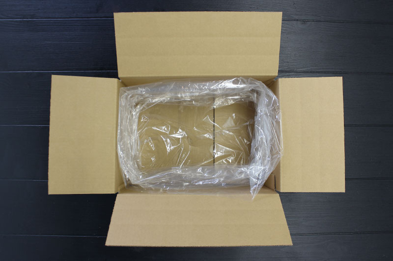 透明な袋をダンボールにセットする